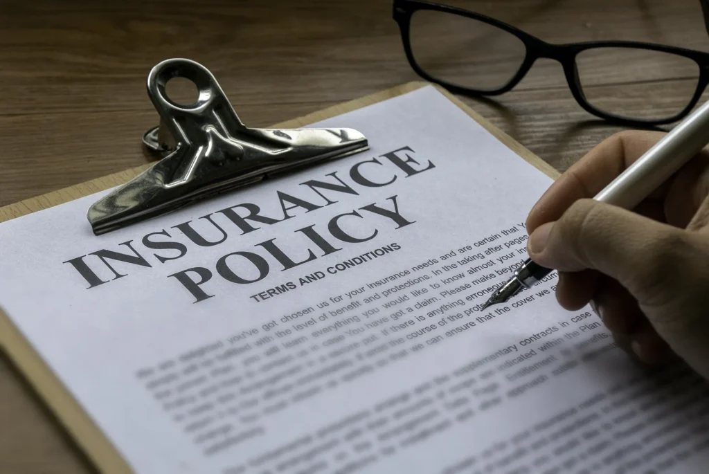 Insurance Policy Claim on a clip board with fountain pen and glasses